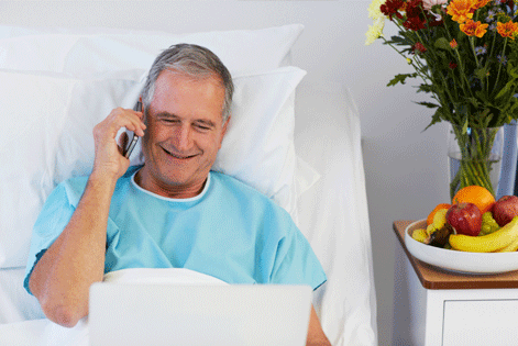 Man in hospital bed receiving a gift