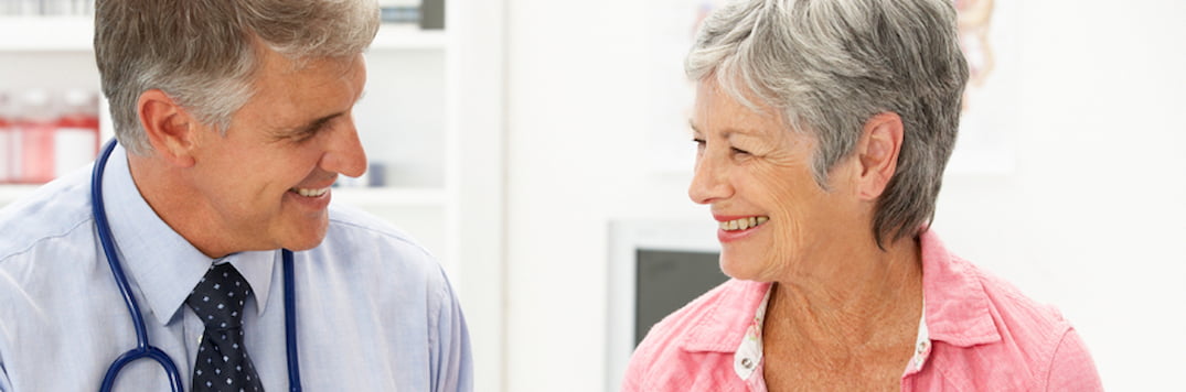 Happy patient smiling and laughing with her doctor.