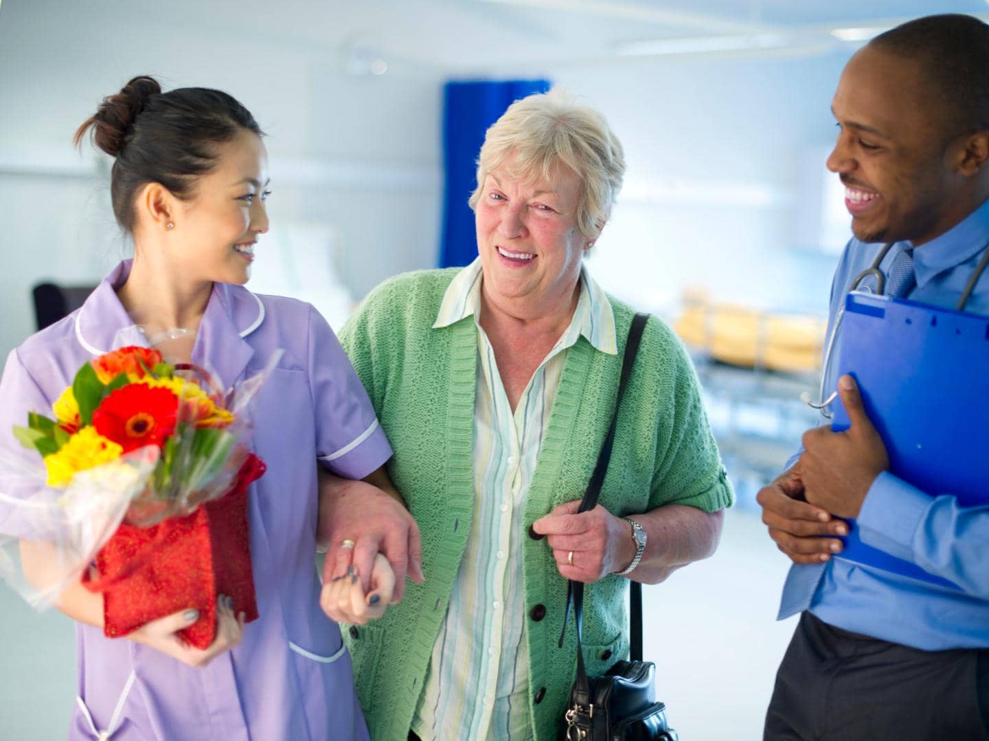 A doctor and nurse helping a woman leave the Hospital