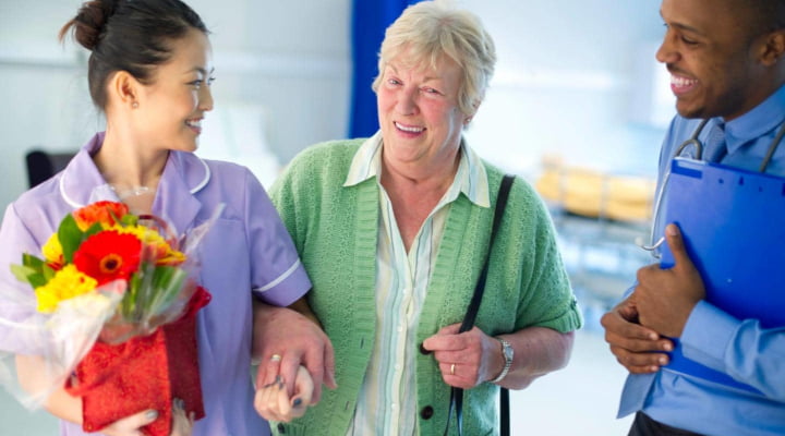 A doctor and nurse helping a woman leave the Hospital